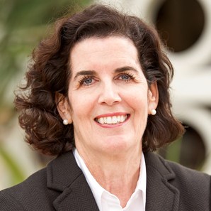 Professional woman smiling in business attire for corporate headshot.