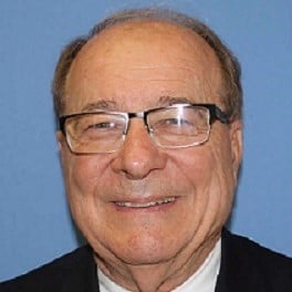 Elder man in smiling portrait showcasing professional appearance and confidence.