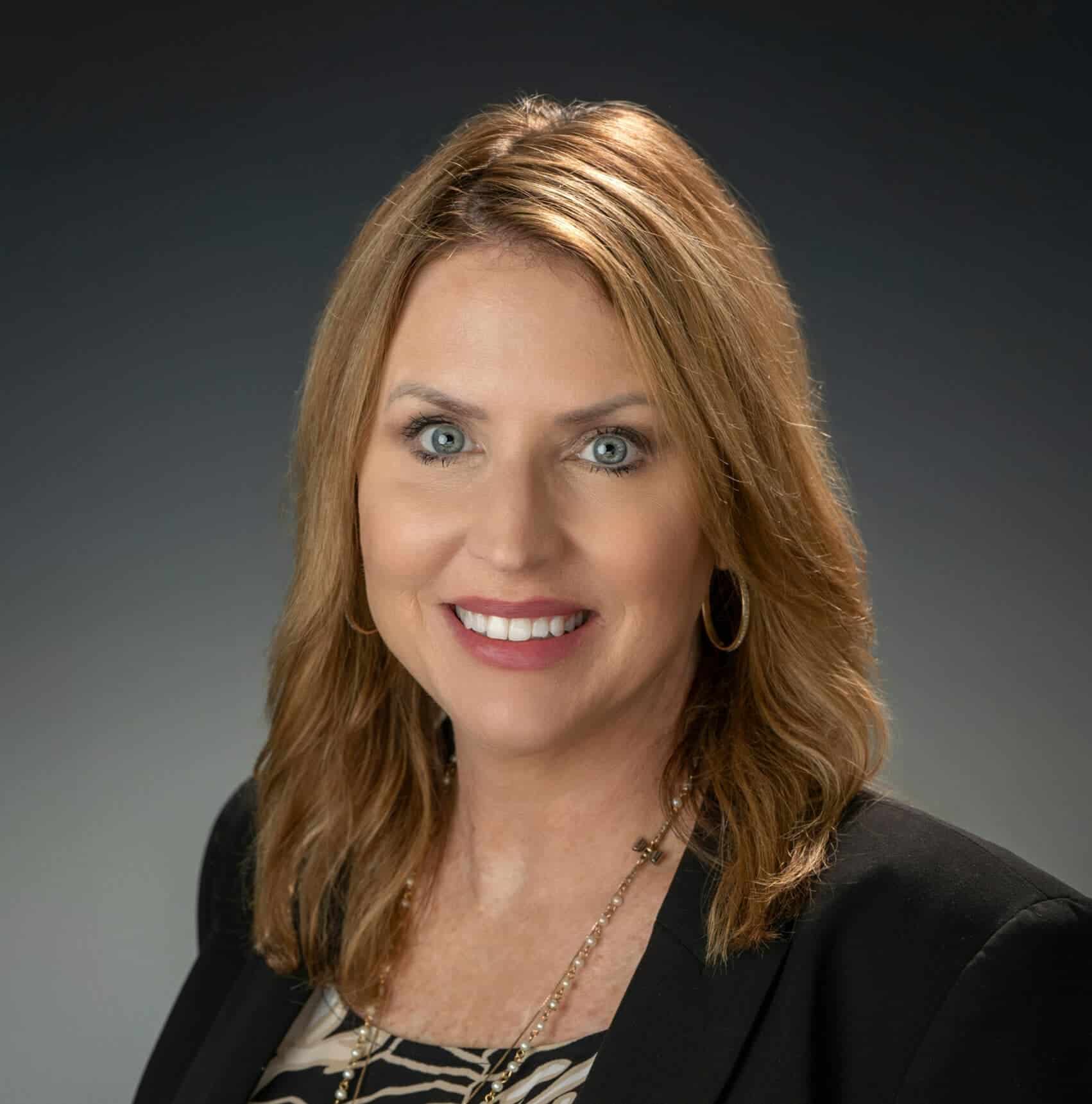 Professional woman portrait, business attire, smiling emphasizing leadership and success.